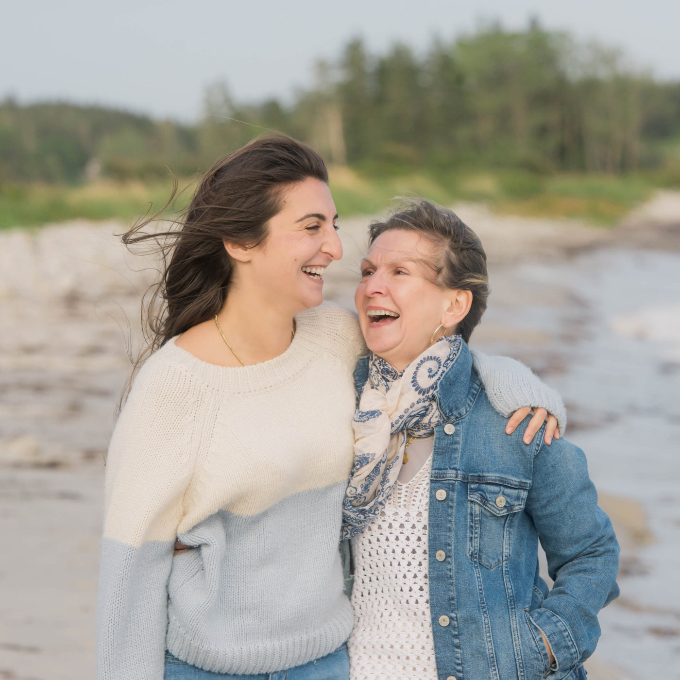 young and old woman on beach laughing